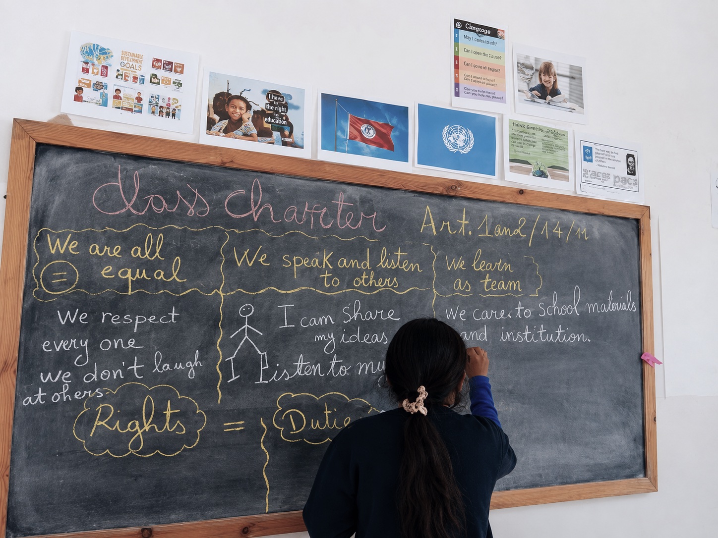 En elev skriver et klassecharter om rettigheder og pligter på klassens tavle